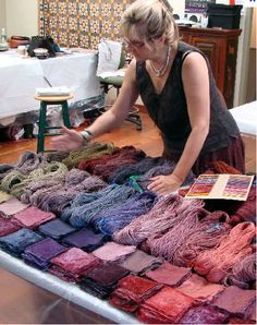 a woman is looking at some yarn on display