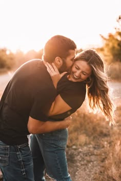 a man and woman embracing each other in an open field