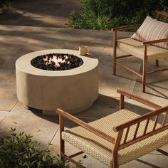 an outdoor fire pit with chairs around it