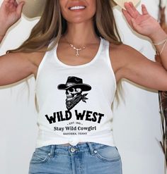 This Wild West Cowgirl Tank Top will have you saddled up in style. This sleeveless shirt combines the classic Western vibe with a hint of western gothic aesthetic, perfect for embracing your cowgirl skeleton. With its racerback fit, this country tank top screams summer vibes and all American cowboy spirit. Whether you're a seasoned bull rider or just love the wild west, this tank is sure to make you feel like the ultimate cowgirl.  * Q U I C K * F A C T S *  ✺ Fabric is made up of 60% soft combed ringspun cotton/40% polyester lightweight jersey ✺ Low cut armhole ✺ Curved bottom hem ✺ Tear away label ✺ Relaxed fit * S I Z I N G * ✺ This is a Ladies Racerback Tank Top ✺ * For an oversized feel, we recommend ordering a size up * S H I P P I N G * T I M E S * ✺ Our items are individually made Western Gothic Aesthetic, Cowgirl Skeleton, Wild West Cowgirl, Western Tank Tops, Cowgirl Top, Country Tank Tops, Gothic Tank Tops, Western Gothic, American Cowboy