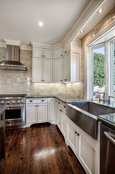 a kitchen with white cabinets and stainless steel appliances is pictured in this image from the inside