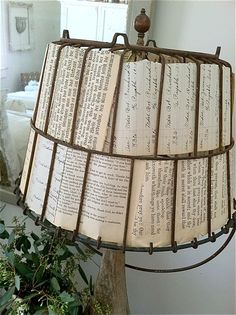 a lamp that is sitting next to a potted plant in a room with lots of papers on it