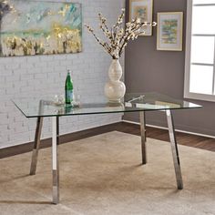 a glass table with metal legs in a room