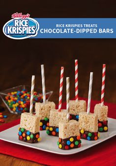 rice krispies treats are arranged on a white plate with candy sticks sticking out of them