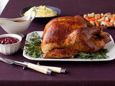 a roasted turkey on a platter with side dishes