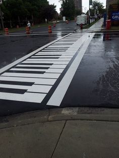 an image of a street that has been painted with piano keys on the road in the rain