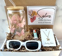 an open box containing sunglasses, a drink and some other items to make the best gift for friends