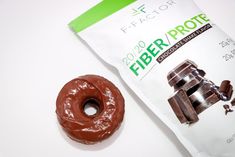 a chocolate doughnut next to a package of fieberr prote on a white surface