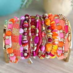 Part Of Our New Signature Stack Collection Of Artisan Beaded Stretch Boho Bracelet Sets. This Super-Sized Set Features Shades Of Coral, Pink, Magenta, Gold, Amber & Orange. Picture Witnessing A Stunning Sunset Seemingly Rising From The Sands Of The Sahara. There Are 14 Gorgeous Beaded Stretch Bracelets And 1 Seed Beaded Pull-To-Fit Tassel Back Bracelet For A Total Of 15 Pcs. The Gold-Dipped Charms Include Feathers, Cactus, Crescent Moon & Geometric Shapes. All Items From Our Own Artisan Line Of Multicolor Bohemian Beaded Bracelets For Festive Occasions, Multicolor Bohemian Beaded Bracelet For Festive Occasions, Hand-strung Pink Jewelry For Festivals, Pink Hand-strung Jewelry For Festival, Pink Beaded Friendship Bracelets For Summer, Summer Beaded Pink Friendship Bracelets, Pink Jewelry With Colorful Beads For Festival, Pink Bohemian Friendship Bracelets As Gift, Pink Bohemian Friendship Bracelets For Gift