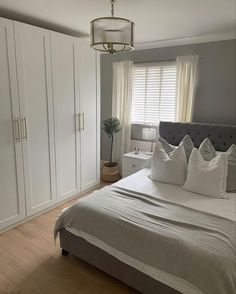 a bedroom with a bed, dresser and white closets in it's corner