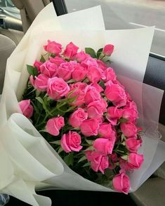 a bouquet of pink roses sitting in the back seat of a car