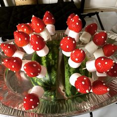 there are strawberries and cucumbers arranged on the plate with marshmallows