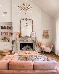 a living room filled with furniture and a fire place under a chandelier on top of a hard wood floor