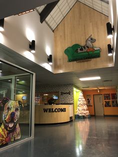 a welcome sign in the lobby of a building with a dog on it's front desk