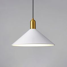 a white and gold colored light hanging from a ceiling fixture in a room with grey walls