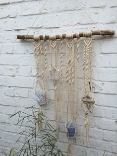 a wall hanging made out of macrame and rope with blue glass ornaments on it