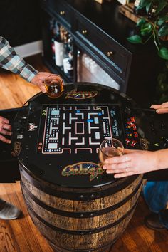 two people are playing a game on an old wooden barrel with some beer in it