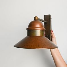 a person is holding up a light fixture