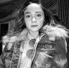 a young woman wearing a jean jacket and fur collar