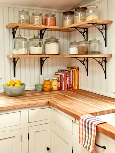 a kitchen with shelves filled with jars, lemons and books