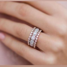 a woman's hand with two rings on her wedding ring, and one is holding the