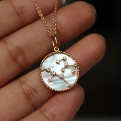 "Diamond studded Zodiac Constellations on a Mother of Pearl Disc with milgrain border, this personalized pendant is a must have! A perfect gift for any occasion for your lovely lady! * Diamond Weight: 0.08-0.13 cts (Depending on the sign) * Color / Clarity : H-I, Vs-Si * Gold - 14K Solid Gold, 1.30 gms (approx) * Chain : 1 mm cable chain (Options in drop down) If you like this ring, please press \"Pin it\" button on the top of your screen. Follow us on Instagram : @abhikajewels Like us on Facebo Luxury Zodiac Sign Round Pendant Jewelry, White Gold Zodiac Sign Round Pendant Jewelry, Luxury Zodiac Sign Jewelry For Anniversary, White Gold Zodiac Sign Jewelry, Round Shape, White Gold Round Zodiac Sign Jewelry, Celestial Zodiac Diamond Jewelry, Celestial Zodiac Sign Diamond Jewelry, Fine Jewelry Diamond Zodiac Sign, 14k White Gold Zodiac Sign Jewelry