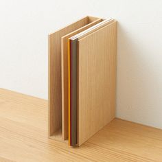 an open book sitting on top of a wooden table next to a white wall and wood floor