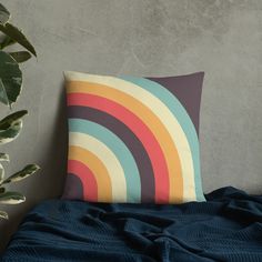 a pillow sitting on top of a bed next to a potted plant in front of a wall