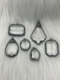 five pieces of glass sitting on top of a white fur covered floor