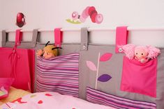 a child's bedroom with pink and gray accessories hanging from the hooks on the wall