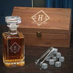 a bottle of whiskey next to some ice cubes and a wooden box on a table