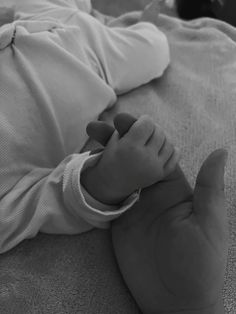 a black and white photo of a baby laying on its back