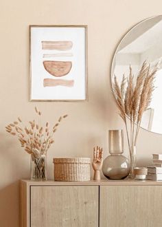 a wooden dresser topped with lots of vases and plants next to a round mirror