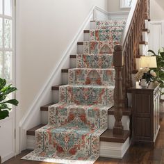 a stair case with carpeted steps and rugs on the bottom, along with potted plants