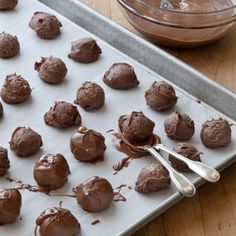 chocolate truffles on a baking sheet with a spoon