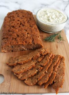 sliced meatloaf on a cutting board with dip