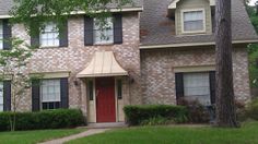 a brick house with a red door and black shutters