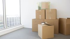 cardboard boxes stacked on top of each other in front of a window with city view