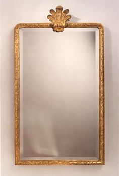 a gold framed mirror hanging on the wall