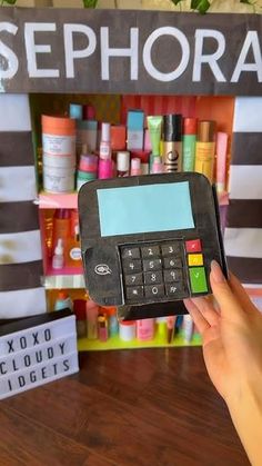 a person holding up a phone in front of a display