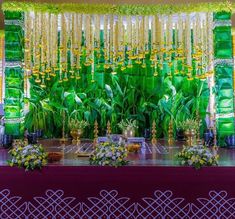 an image of a stage set up with flowers and plants on the side for a wedding ceremony