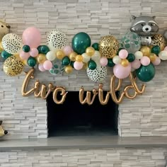 a fireplace decorated with balloons and streamers that spell out the word'wild '