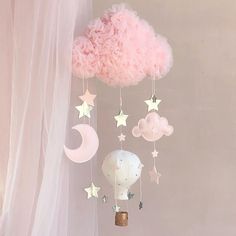 a pink cloud mobile with stars and clouds hanging from it