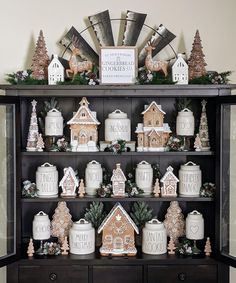 a hutch filled with christmas decorations and gingerbread houses