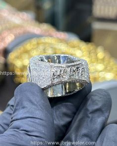 a person holding a ring in their hand with gold and diamonds on it's sides