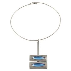 Danish jewelry artist Jorgen Jensen designed this elegant Space Age modernist collar pendant-necklace. The piece is all made in pewter with arctic blue poured glass cabochons. The artist's signature is at the back and reads Pewter - Jorgen Jensen - Denmark. The necklace is in good condition, with minor wear on the metal. Measurements: The collar circumference is 16.13 in (41 cm) - The pendant is 3.13 in high (7.9 cm) x 1.69 in wide (4.2 cm) - The necklace will fit a Small to Medium size neck. No Antique Choker, Gold Collar Necklace, Beautiful Chokers, Jewelry Artist, Modernist Jewelry, Arctic Blue, Choker Pendant, Pewter Metal, Vintage Wardrobe