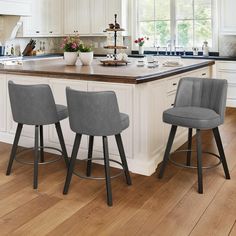 three grey bar stools sit at the center of a kitchen island