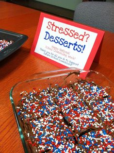 a glass dish filled with chocolate sprinkles next to a sign that reads stressed desserts