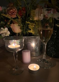 two wine glasses and one candle on a table