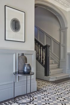 a black and white checkered floor with a vase on the table next to it